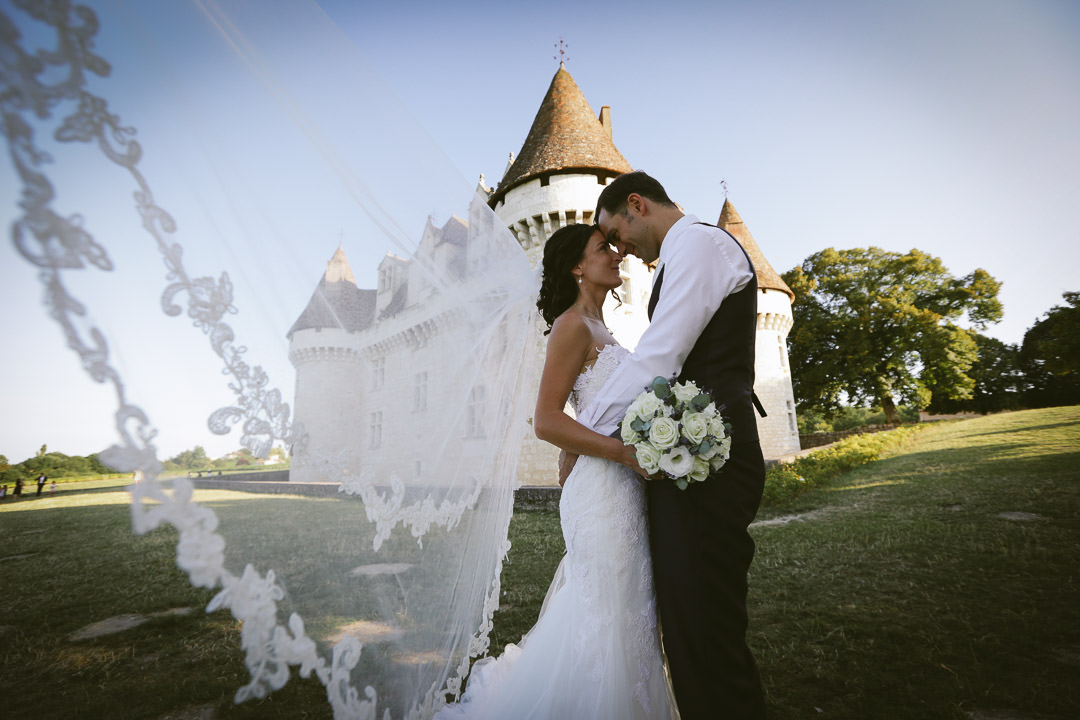 Gujant-mestras - Couple de jeune mariés s'enlaçant devant un château